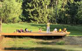 Start in den Tag auf der Yoga-Plattform im Garten